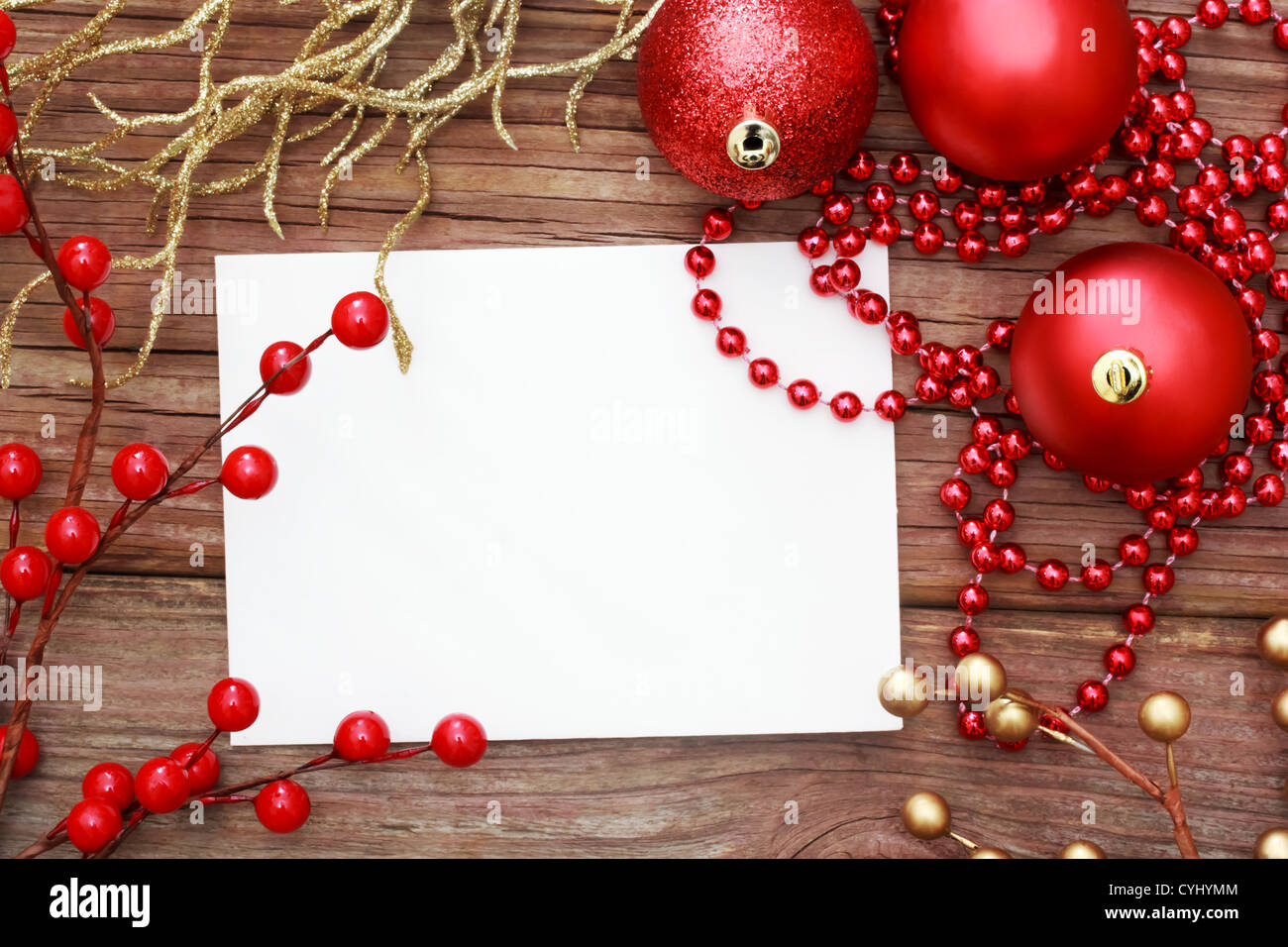 Red Christmas ornaments on wood with note card Stock Photo