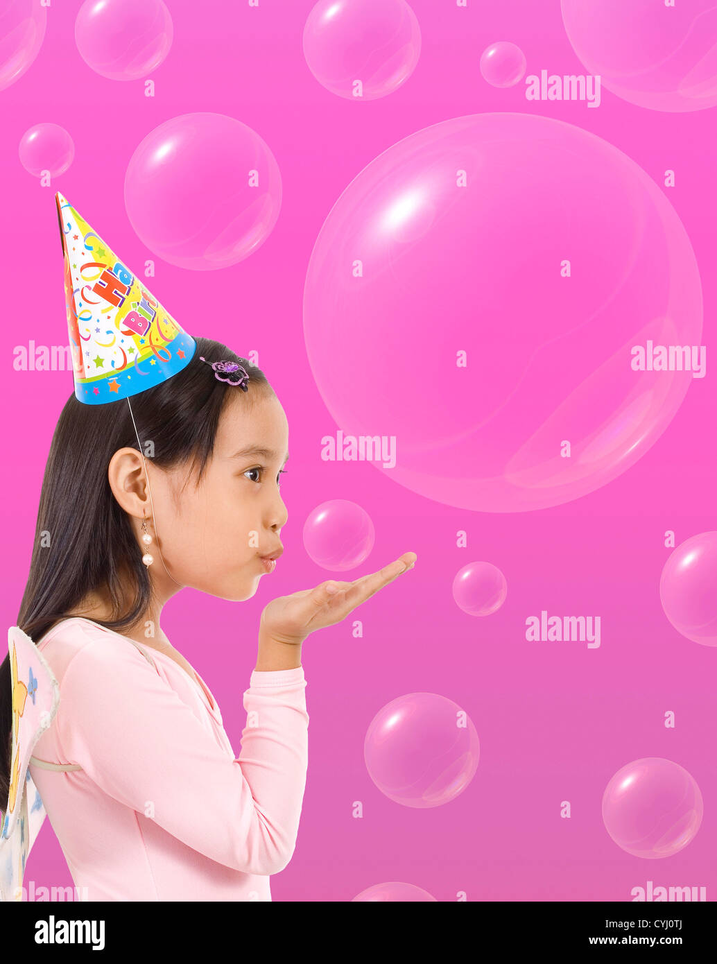 Happy Girl In A Party Hat Blowing Bubbles Stock Photo Alamy