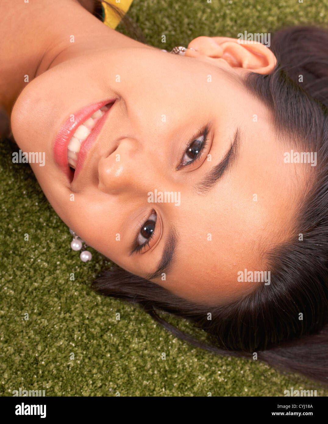 Smiling Girl Relaxed And Contented On The Grass In The Garden Stock Photo