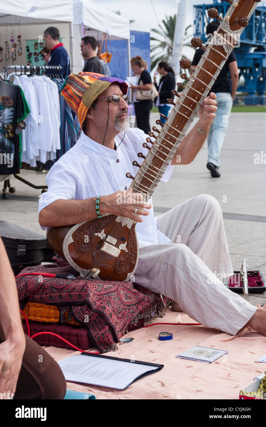 Sitar player near market stalls at WOMAD festival in Las Palmas, Gran Canaria, Canary Islands