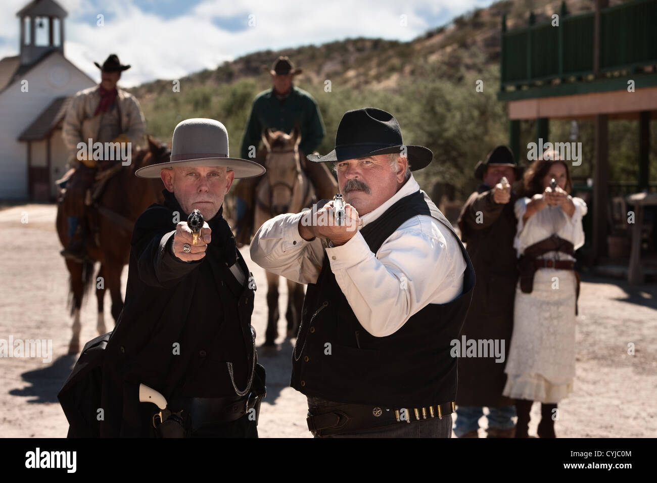 Brave men aim their guns in old west town Stock Photo