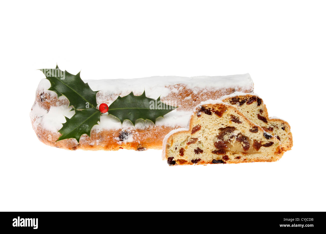 Icing sugar dusted Christmas stollen with slices cut and a sprig of holly isolated against white Stock Photo