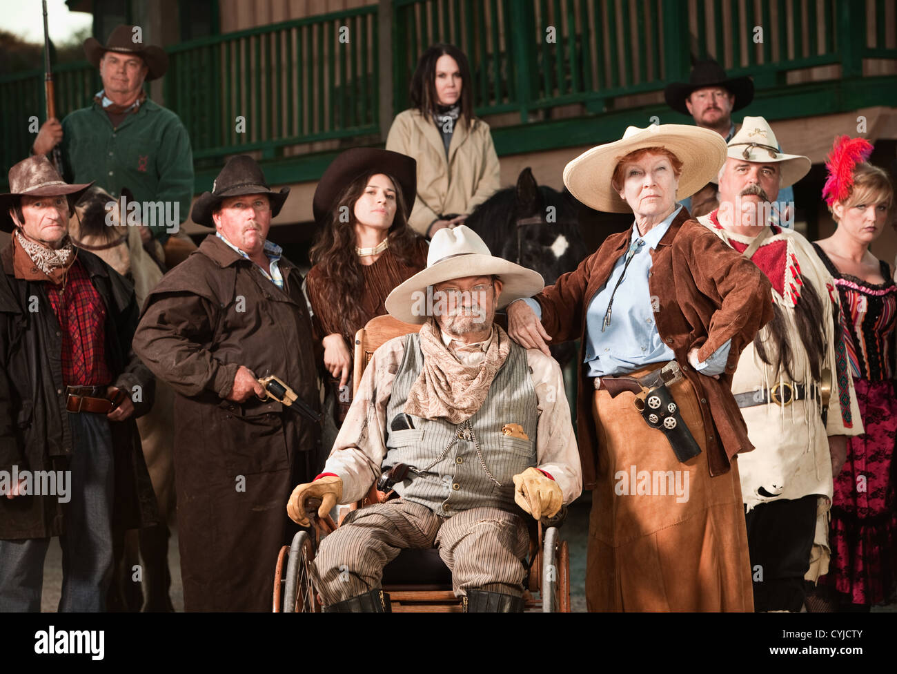 Wheelchair bound cowboy with wife and old west era gang Stock Photo - Alamy