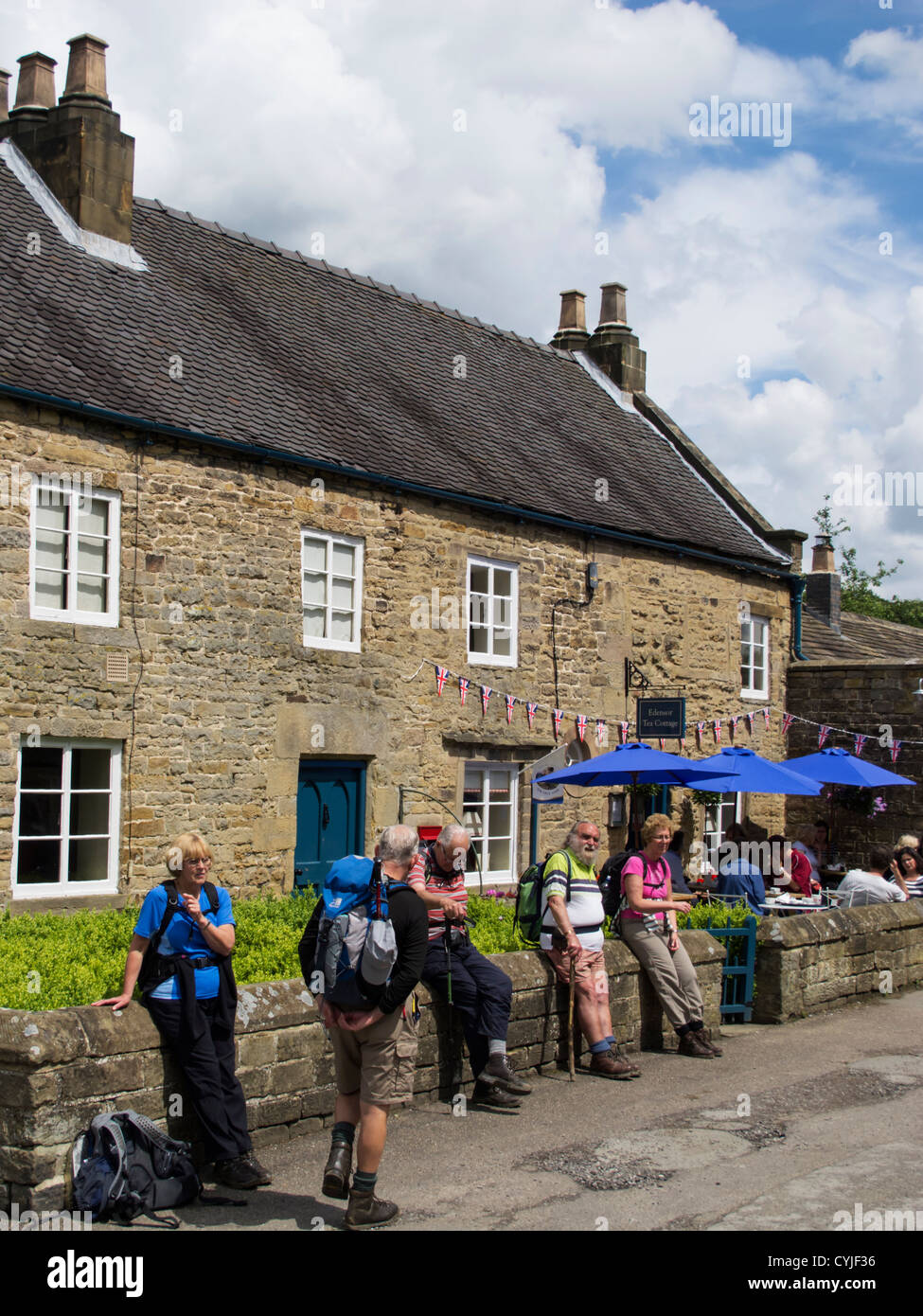 Hikers and walkers standing outside the tea rooms in Edensor village on the Chatsworth Estate in Derbyshire England Stock Photo
