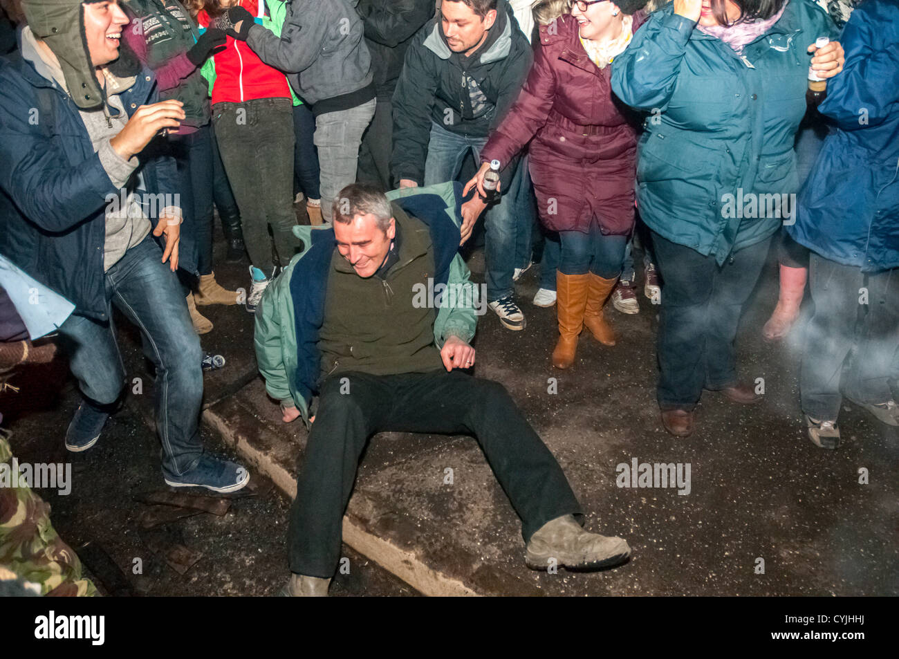 A man is knocked to the ground by the barrel rollers during the 2012 Tar barrel Burning in Ottery St Mary, Devon, UK. 5th November 2012. Stock Photo