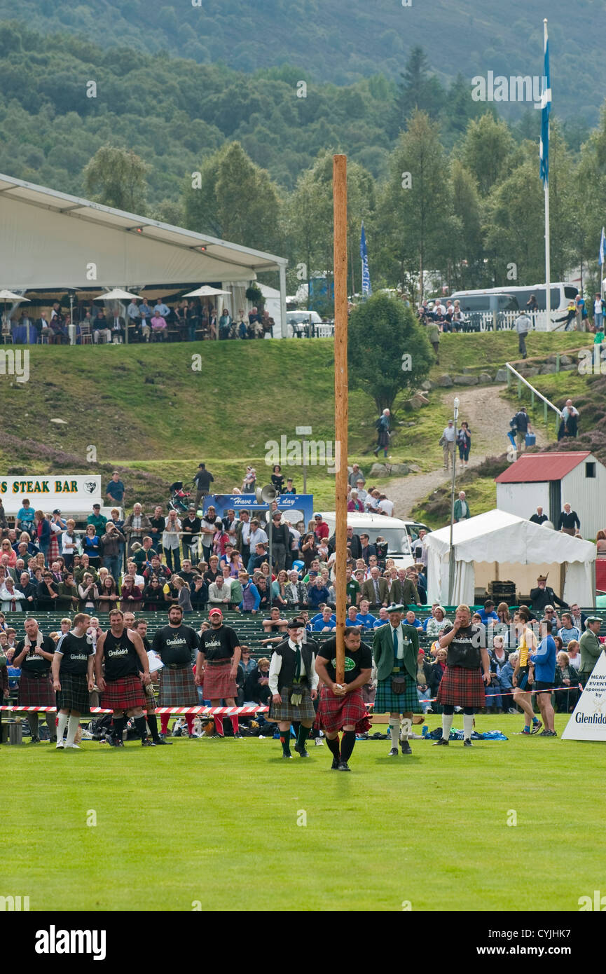 Man competing in a "Toss the Caber" competition at the Royal Highland ...
