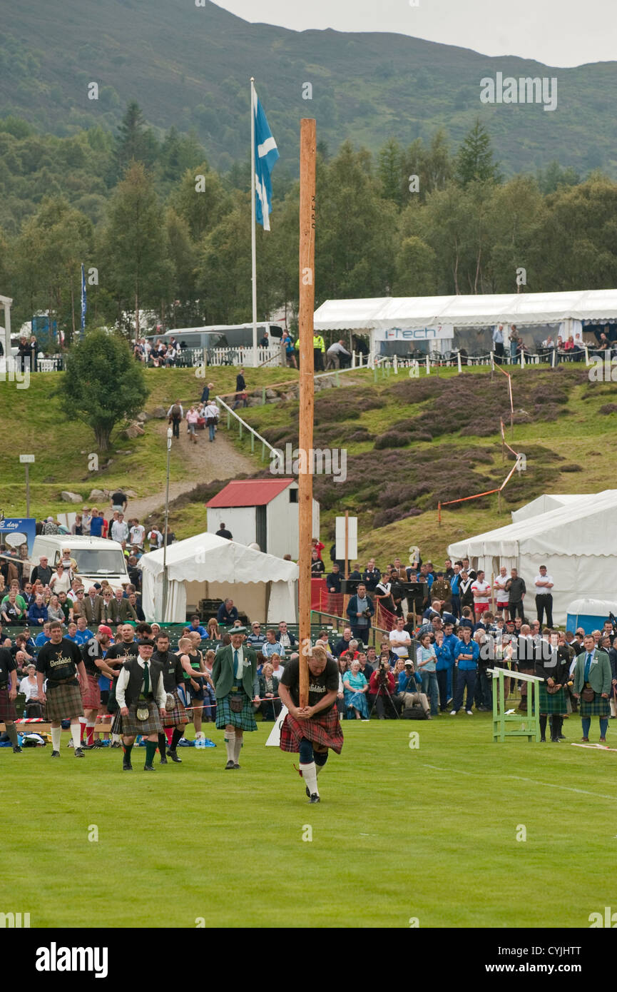 Man competing in a "Toss the Caber" competition at the Royal Highland ...