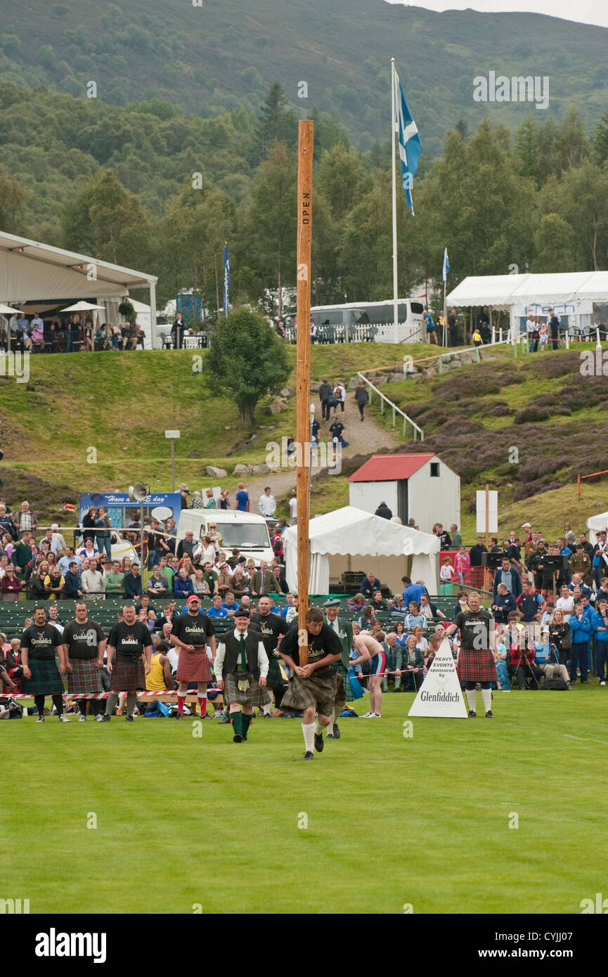 Man competing in a "Toss the Caber" competition at the Royal Highland ...