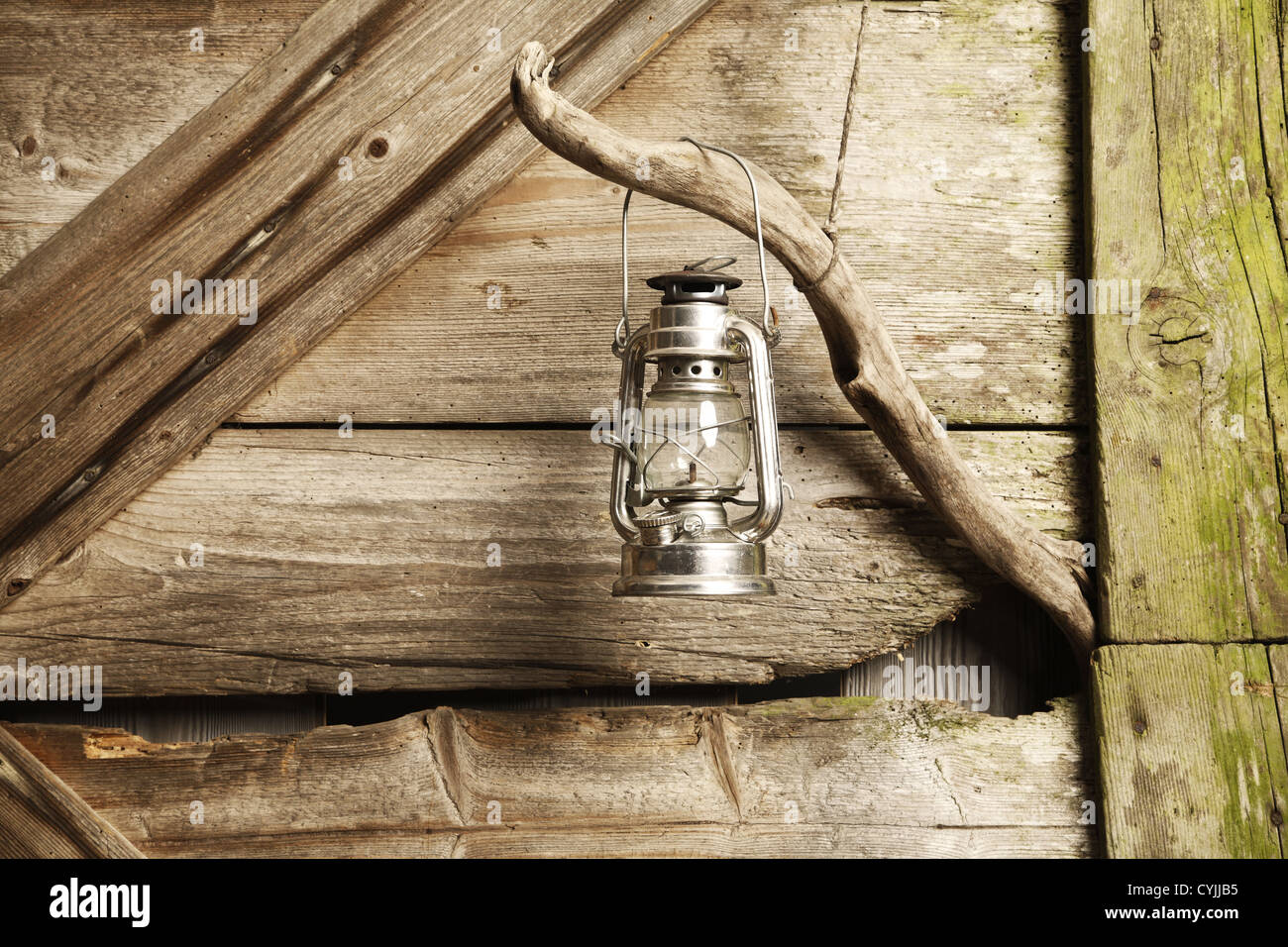 A Old Rustic Oil Lantern On A Wood Block At A Camping Site Stock