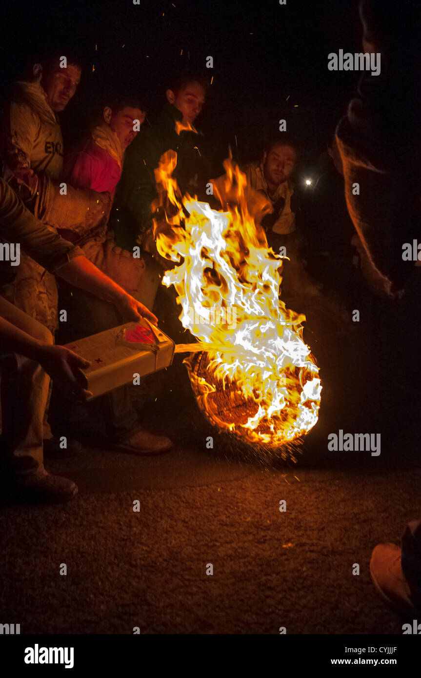 Paraffin is poured into the flaming tar barrel during the 2012 Tar barrel Burning in Ottery St Mary, Devon, UK. 5th November 2012. Stock Photo