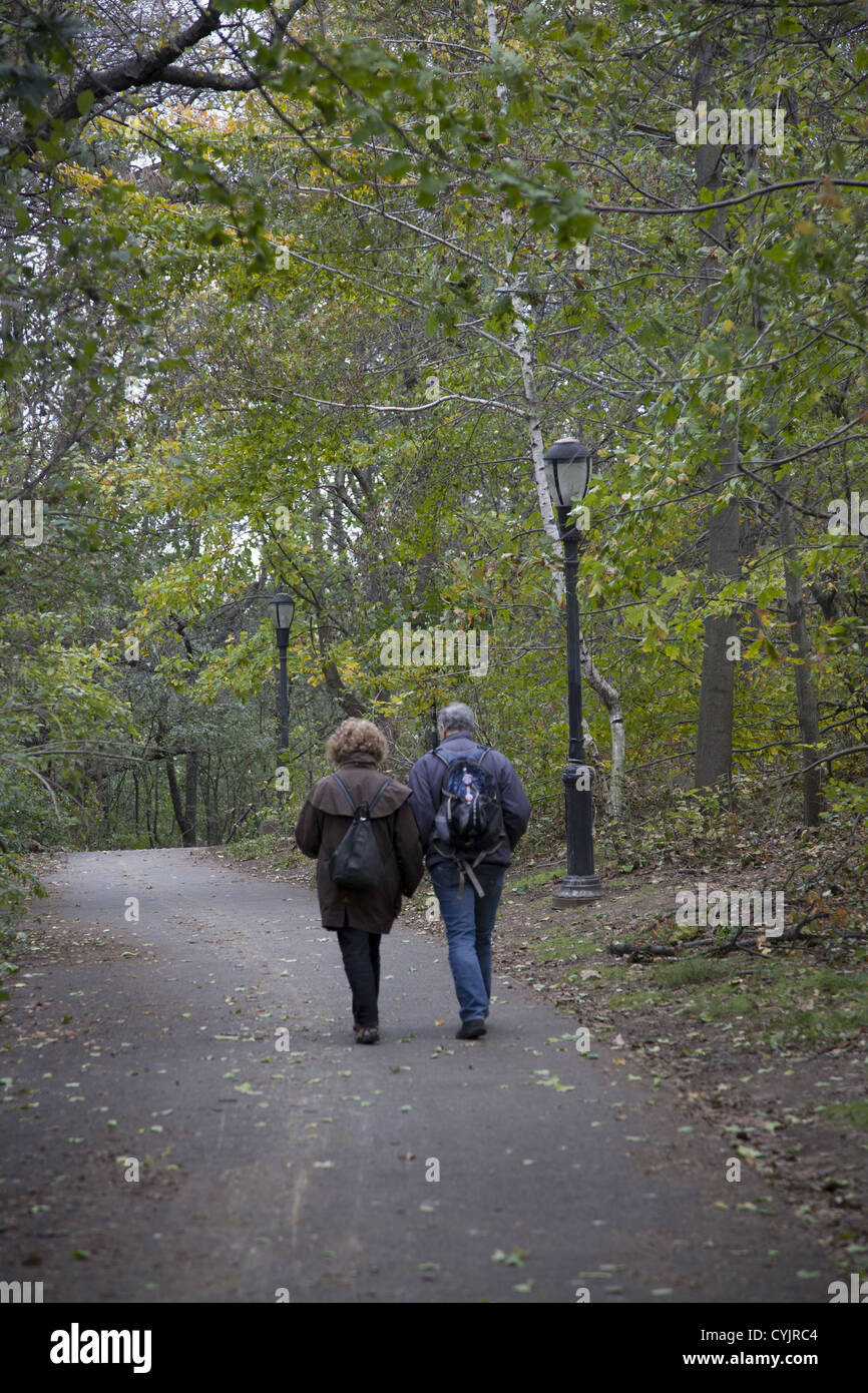 Middle age couple walks hand in hand along a walkway on a fall day in Prospect Park, Brooklyn, NY Stock Photo