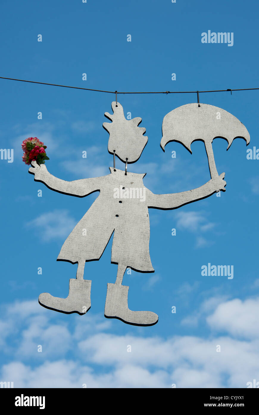 Canada, Quebec, Quebec City. Whimsical metal hanging art figure with flowers, raincoat. Stock Photo