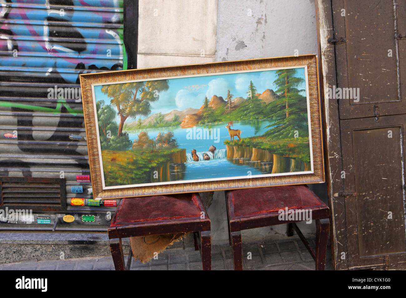 Chintzy kitsch genre landscape oil painting for sale street pavement stall, El Rastro, Madrid, Spain Stock Photo