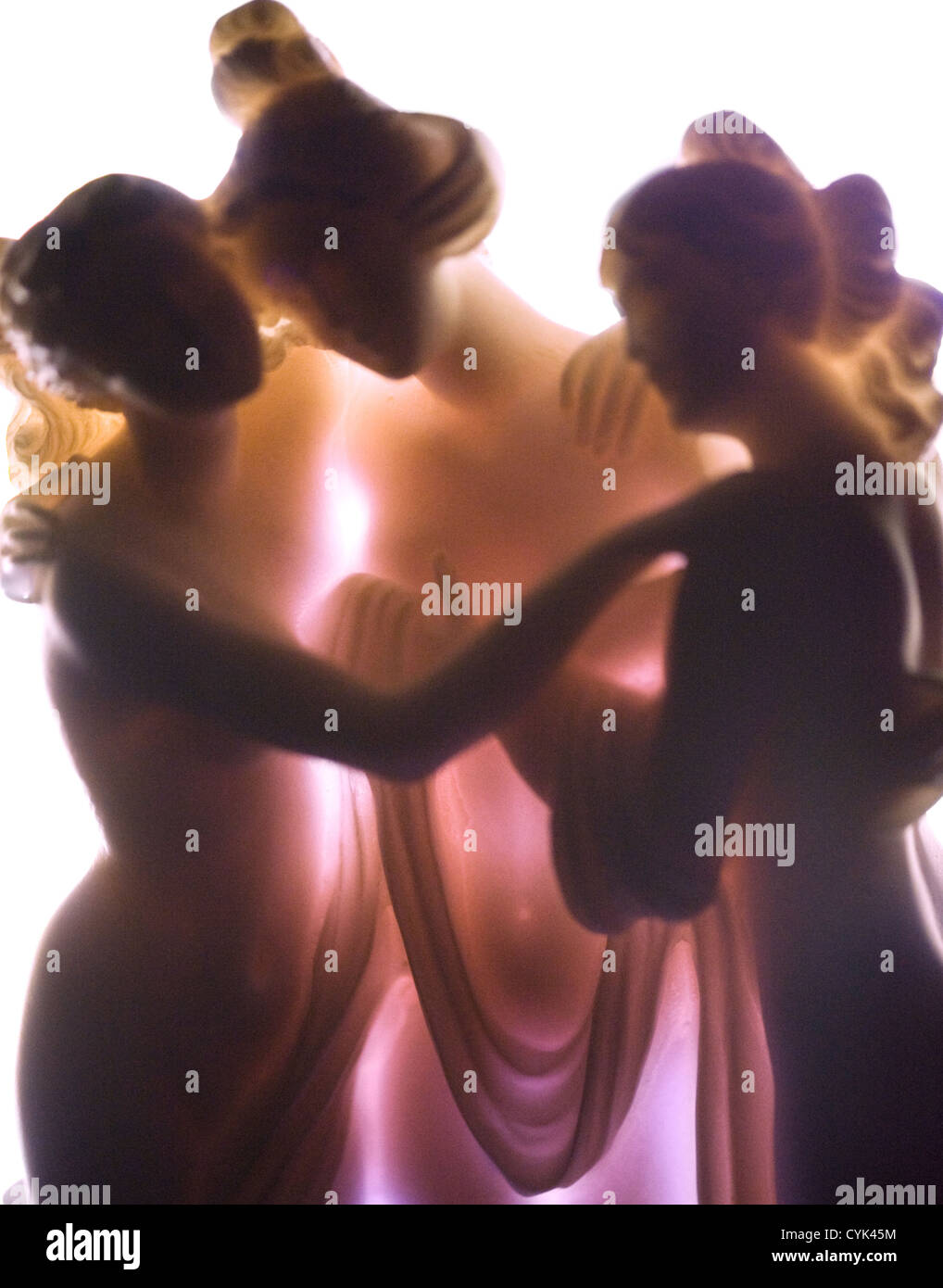 The Three Graces, young women, a porcelain figurine photographed with intense light behind Stock Photo