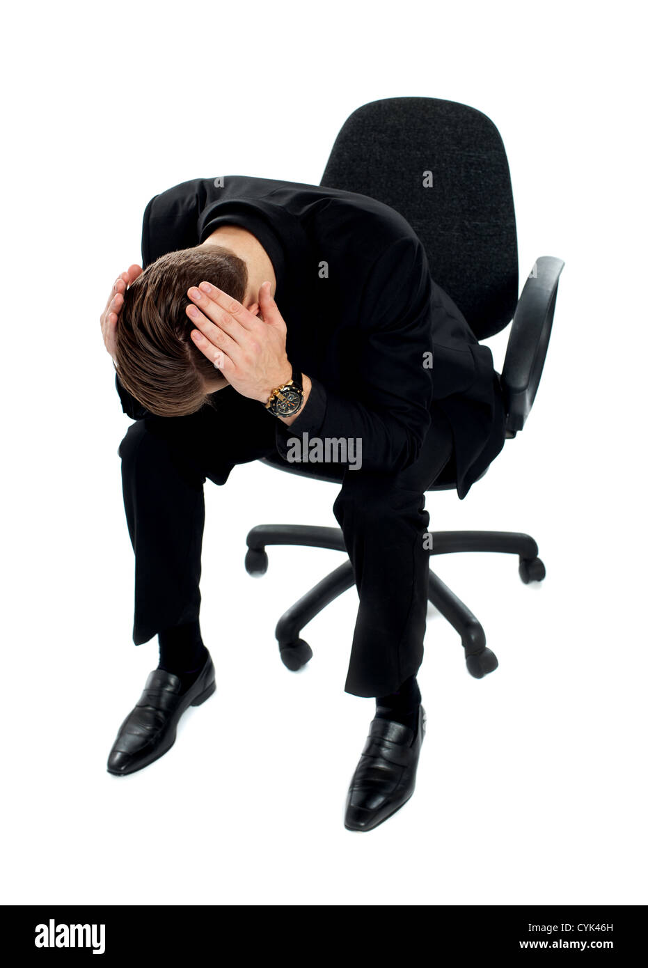 Frustrated man sitting on chair with hands on his head Stock Photo