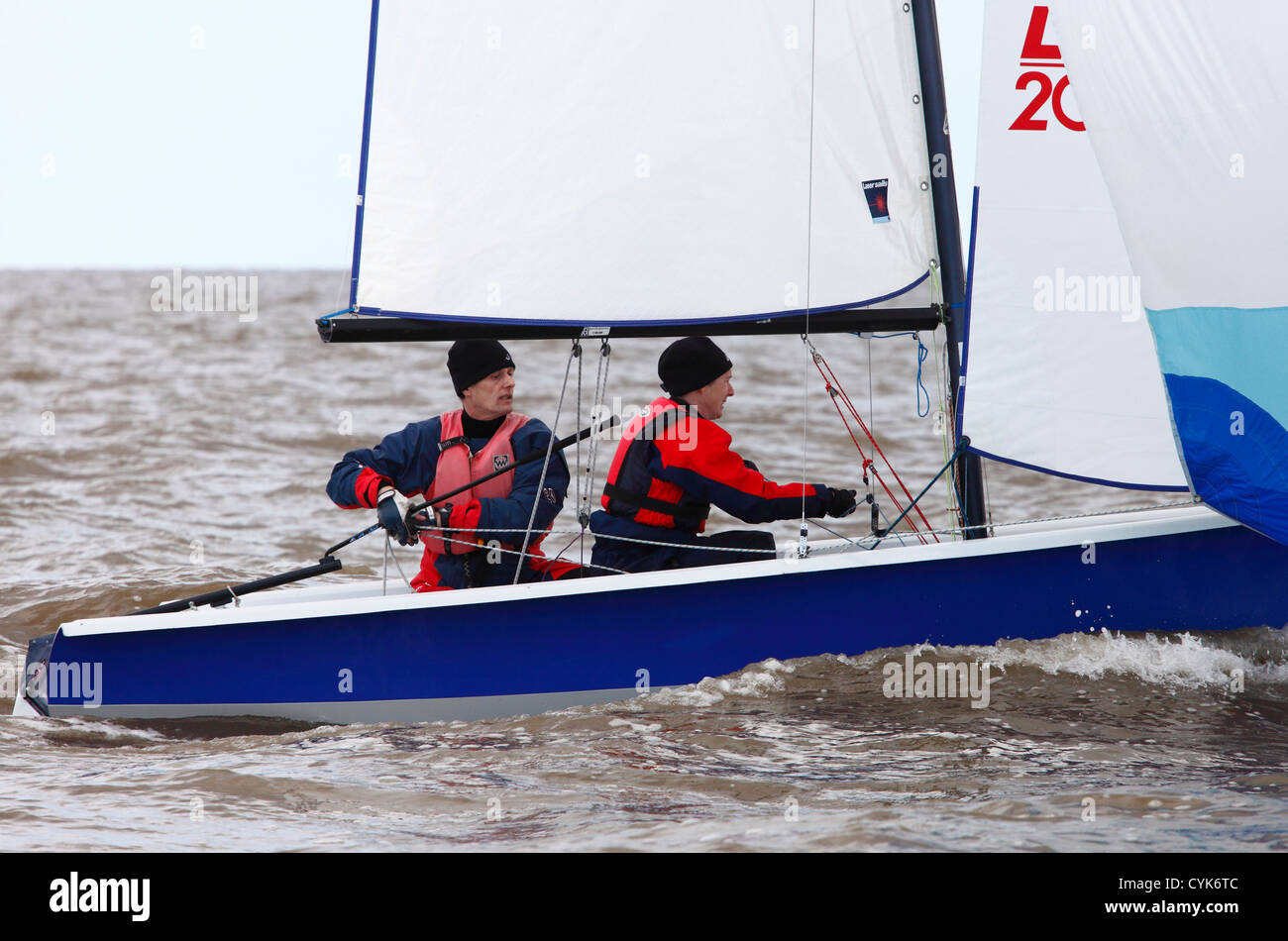 Middle age couple sailing in Laser 2000 class meet at Snettisham in Norfolk. Stock Photo