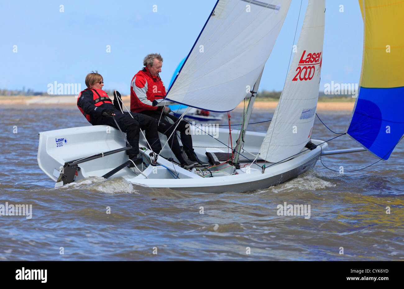 Middle age couple sailing in Laser 2000 class meet at Snettisham in Norfolk. Stock Photo