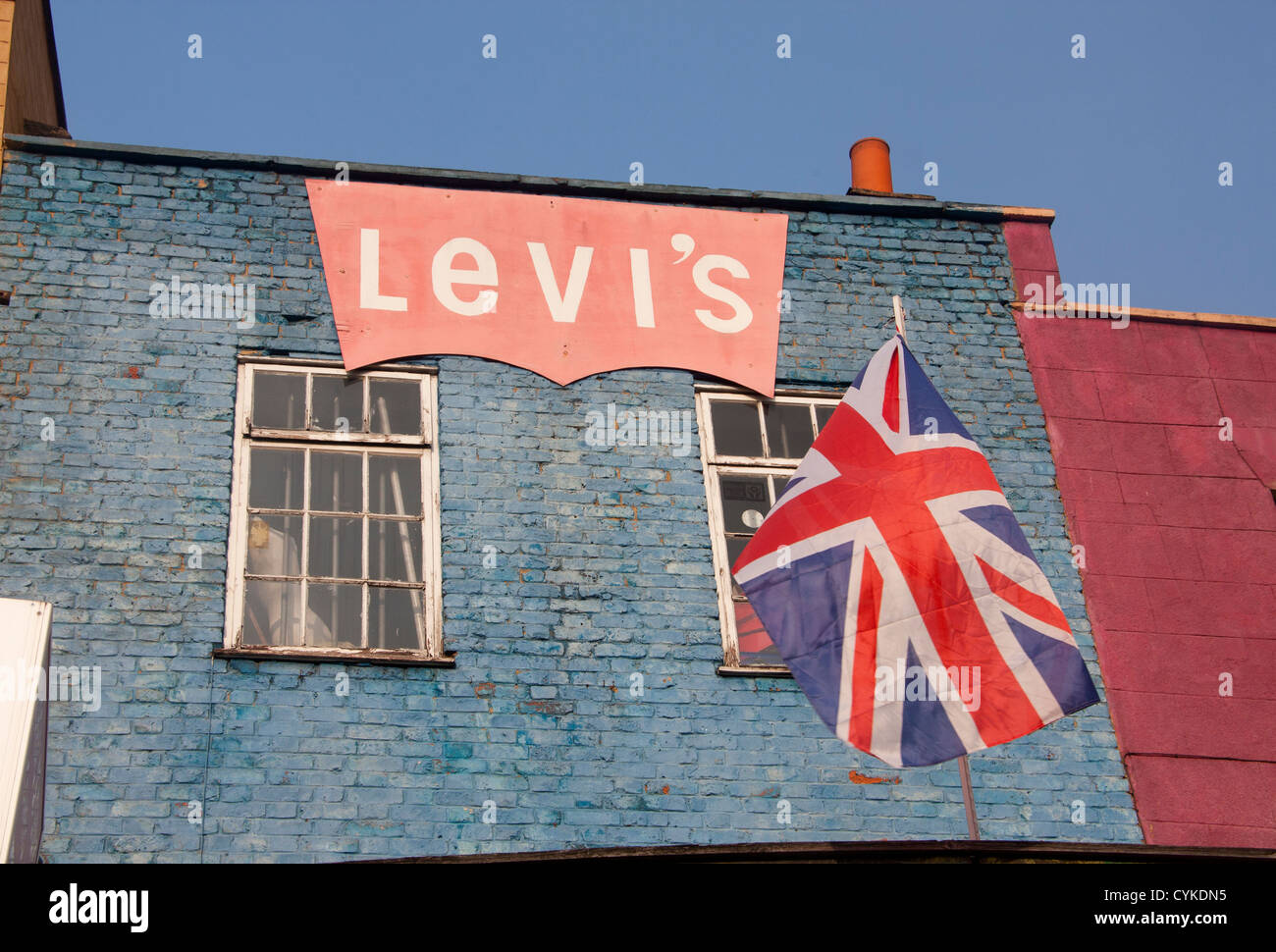 Shop building front on Camden High Street with painted Levi's jeans logo and Unon Jack flag London England UK Stock Photo