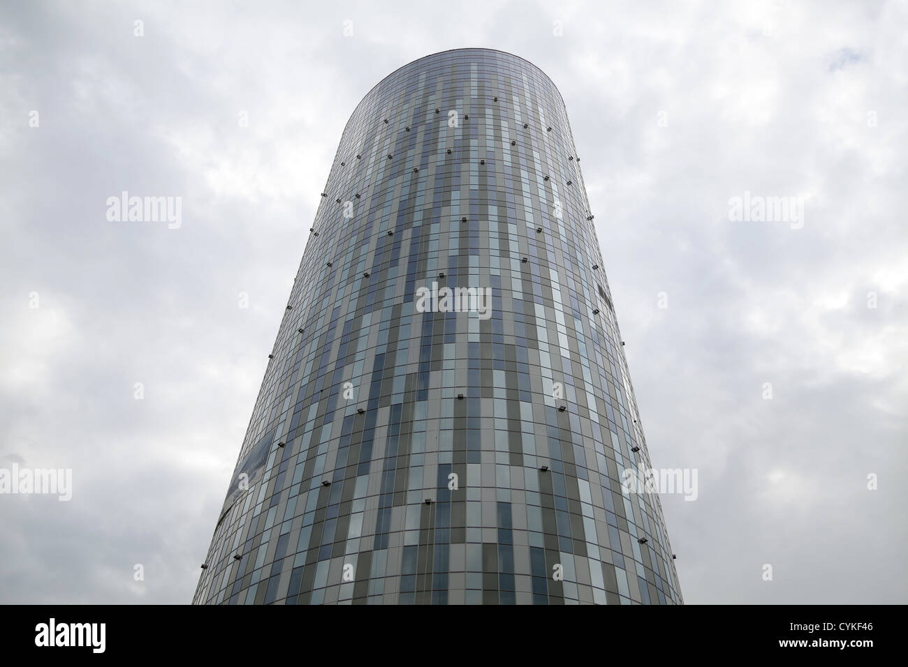 A tall round office building against a cloudy sky Stock Photo - Alamy