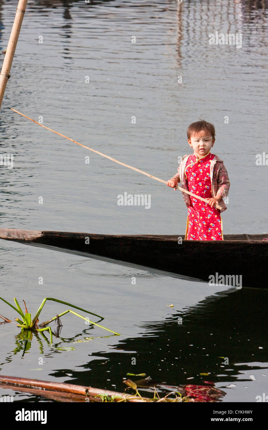 Myanmar, Burma. Little Burmese Child of Intha Ethnic Group Standing in a Canoe, Inle Lake, Shan State. Stock Photo