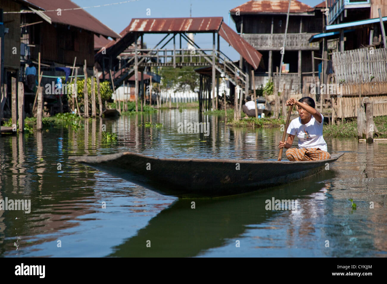 Myanmar, Burma. Woman Rowing Canoe on Village Waterway, Inle Lake, Shan State. Stock Photo