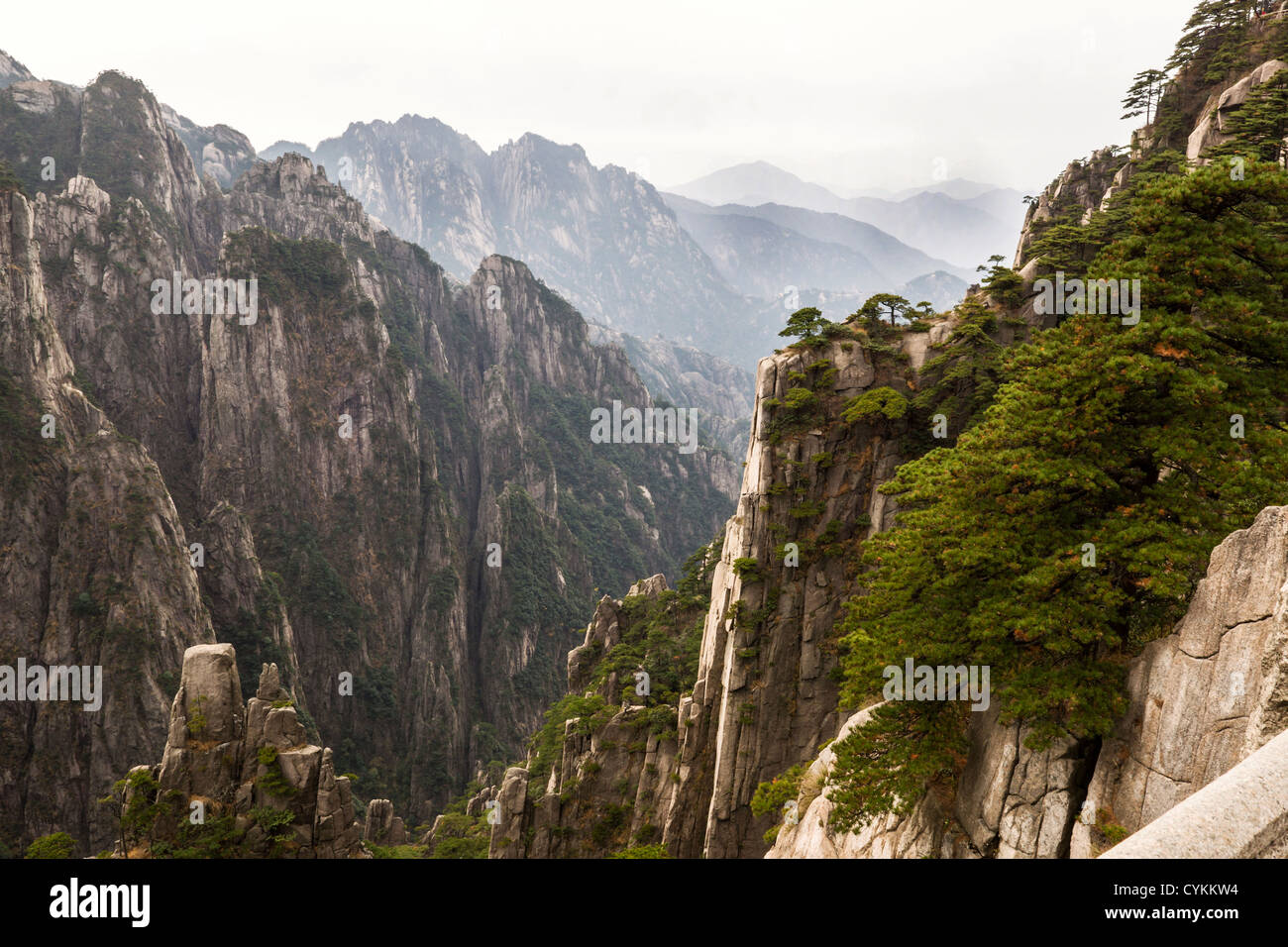 Deep valley in China's Yellow Mountains with cloudy sky in background