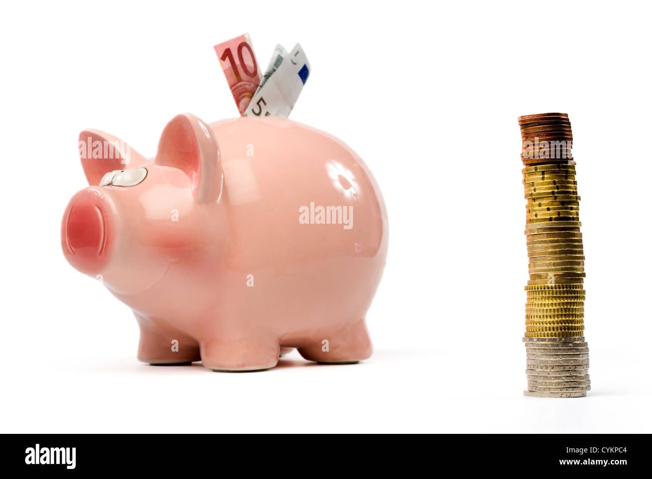 A saving pig with stapled euro coins in front Stock Photo