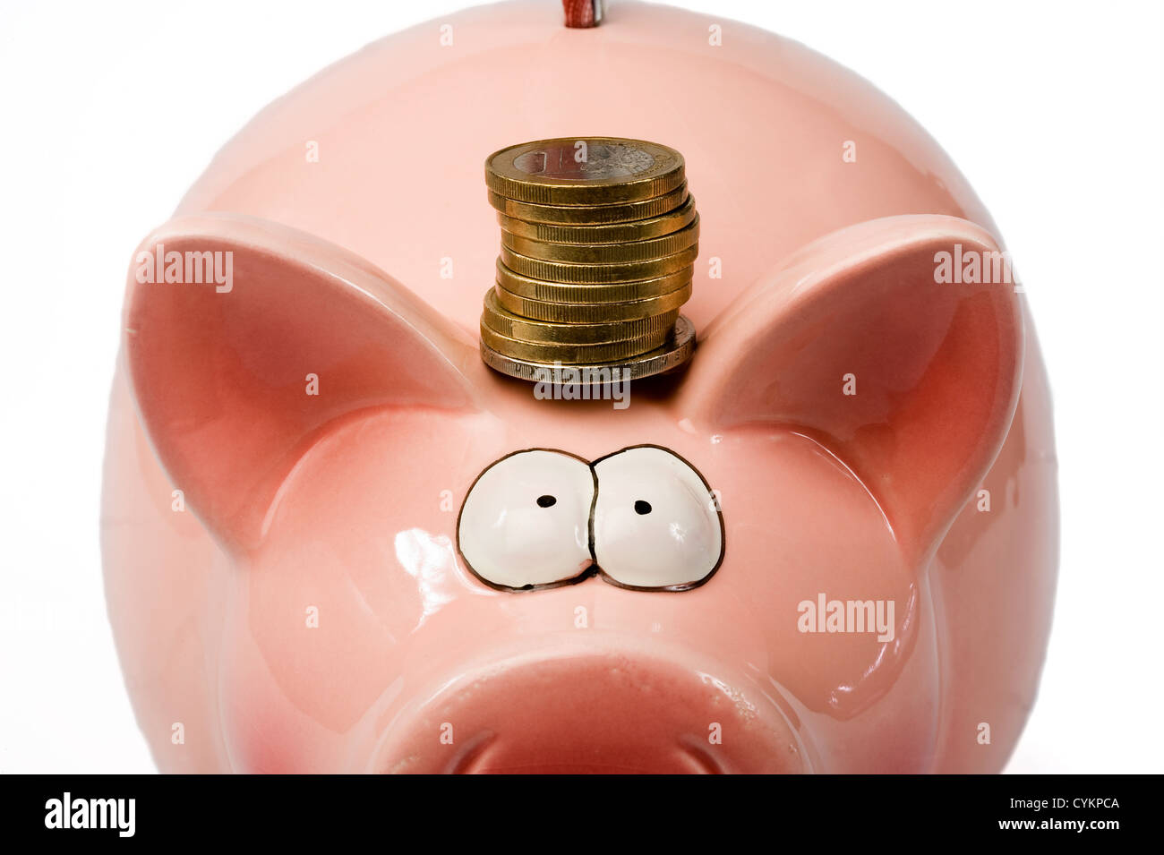A saving pig with euro coins between his ears Stock Photo