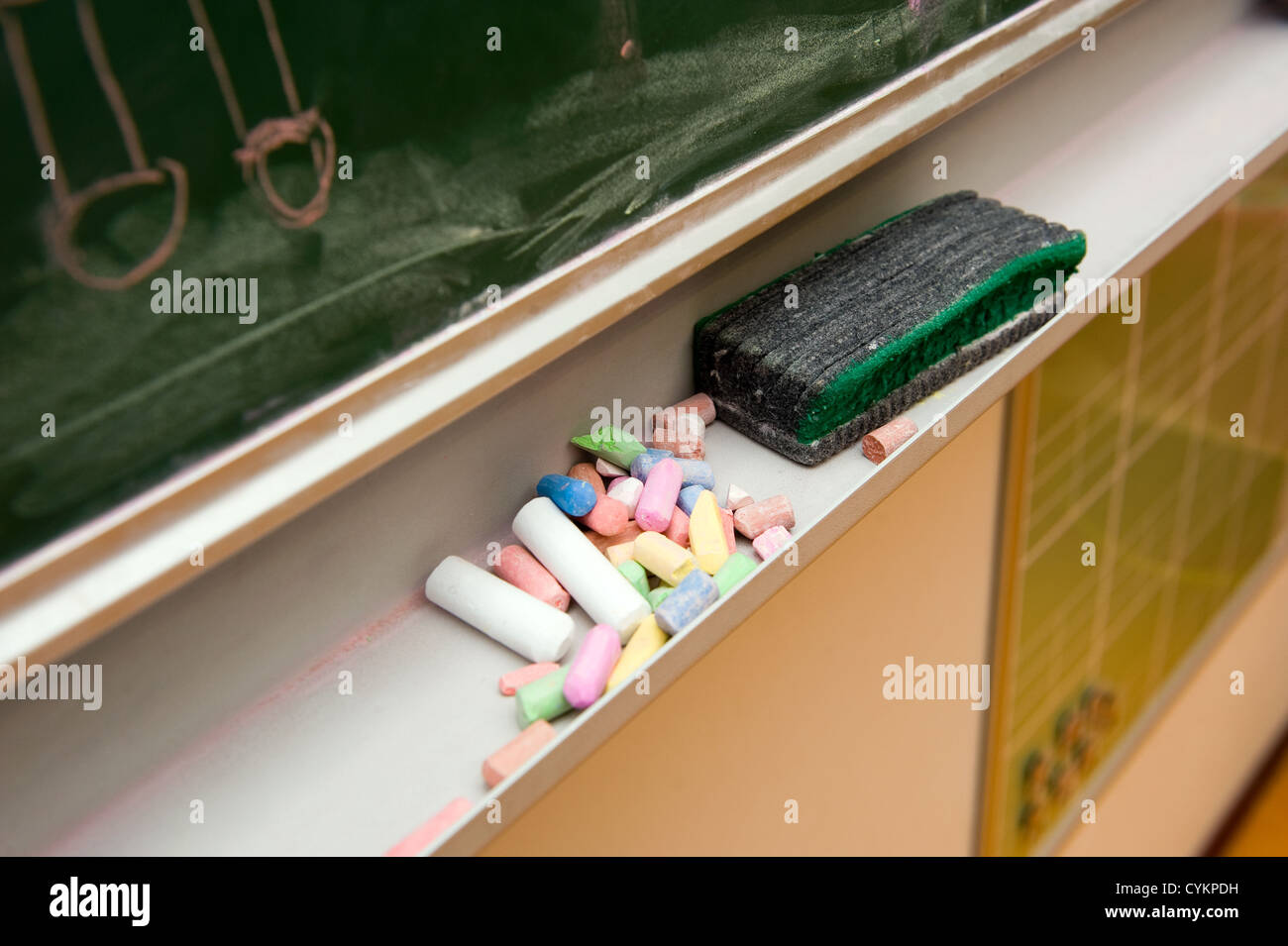 Pieces of chalk and a blackboard in the classroom of a school Stock Photo