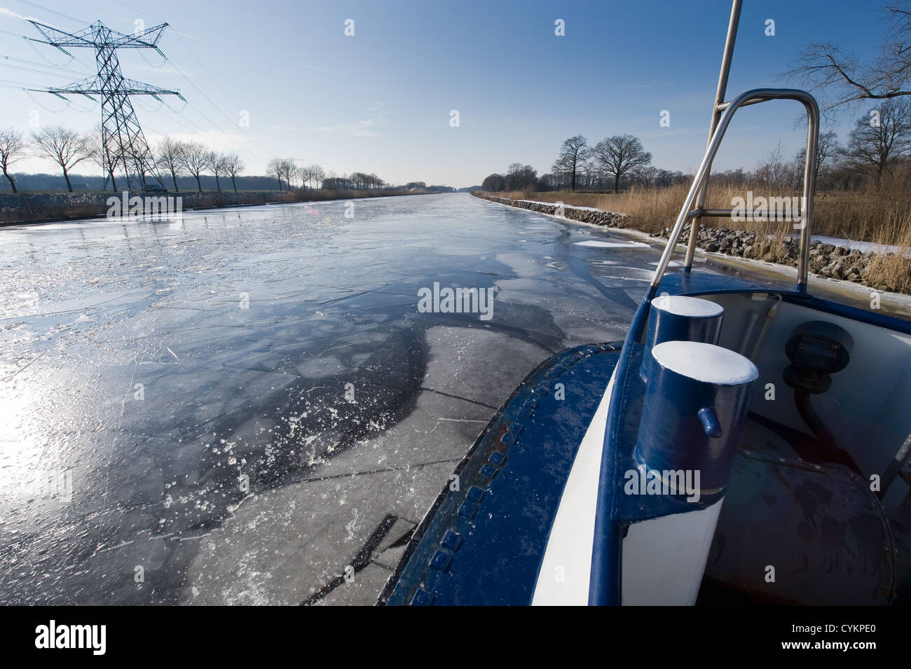 Icebreaker in Dutch canal breaks the ice in pieces Stock Photo