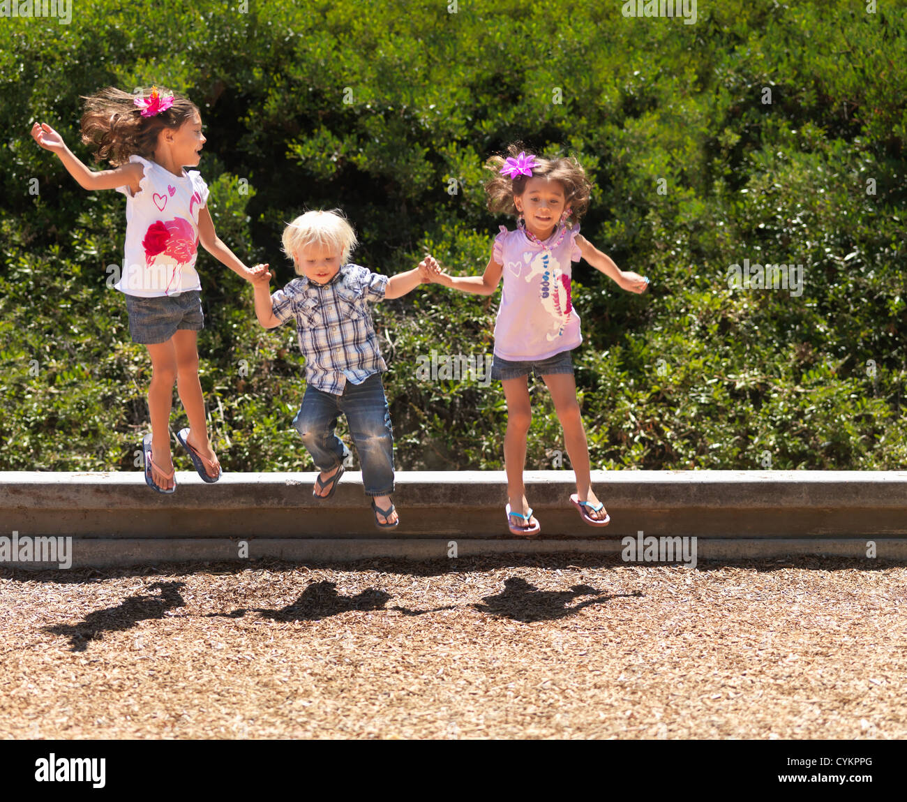 Children jumping together in park Stock Photo - Alamy