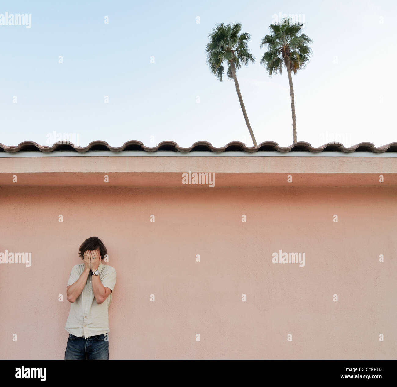 Man covering his face outdoors Stock Photo - Alamy