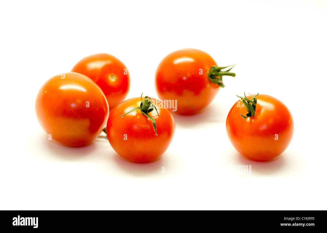 Some tomatos isolated on white background Stock Photo - Alamy