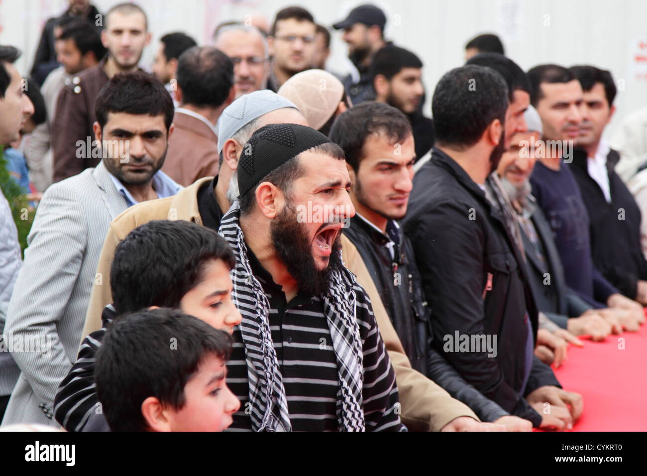 Istanbul, Turkey. 6th November, 2012. Gaza Freedom Fleet supporters rally in front of Istanbul courthouse. Ringleader urging the demonstrators holding a gigantic Turkish flag to go on with their chats. Most slogans were anti-Israel. Credit:  Johann Brandstatter / Alamy Live News Stock Photo