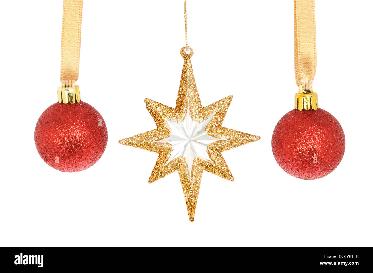 Red Christmas baubles and a gold glitter star isolated against white Stock Photo