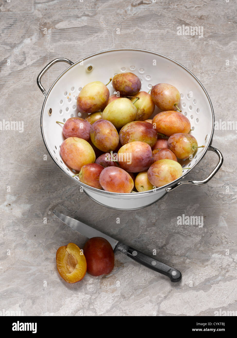 Close up of plums in colander Stock Photo