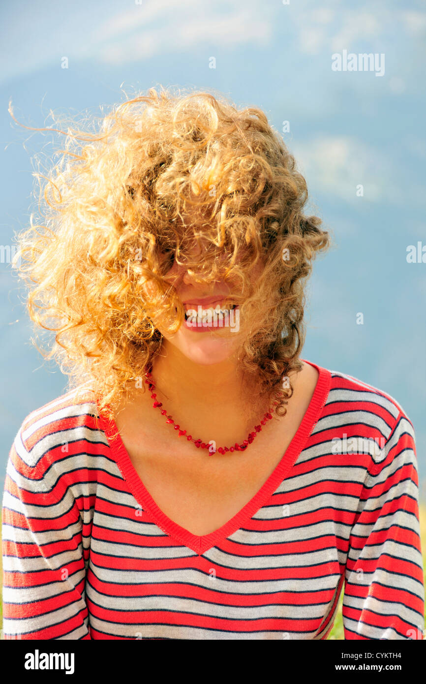 Smiling woman’s hair blowing in wind Stock Photo