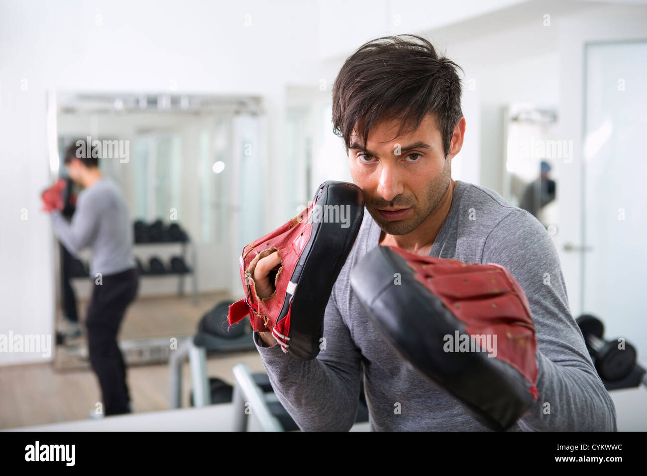 Trainer wearing padded gloves in gym Stock Photo Alamy