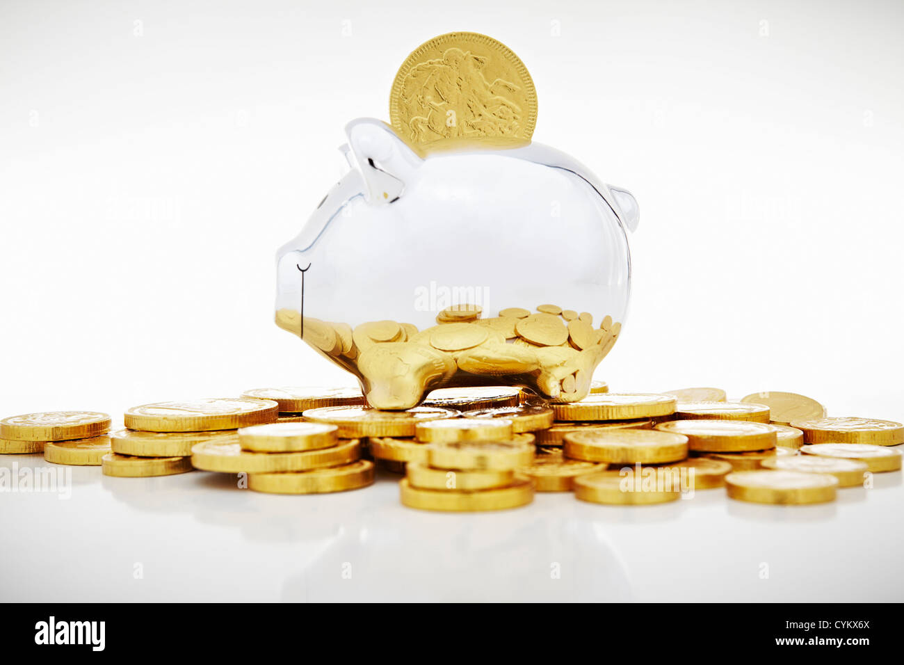 Stack of gold coins by piggy bank Stock Photo - Alamy