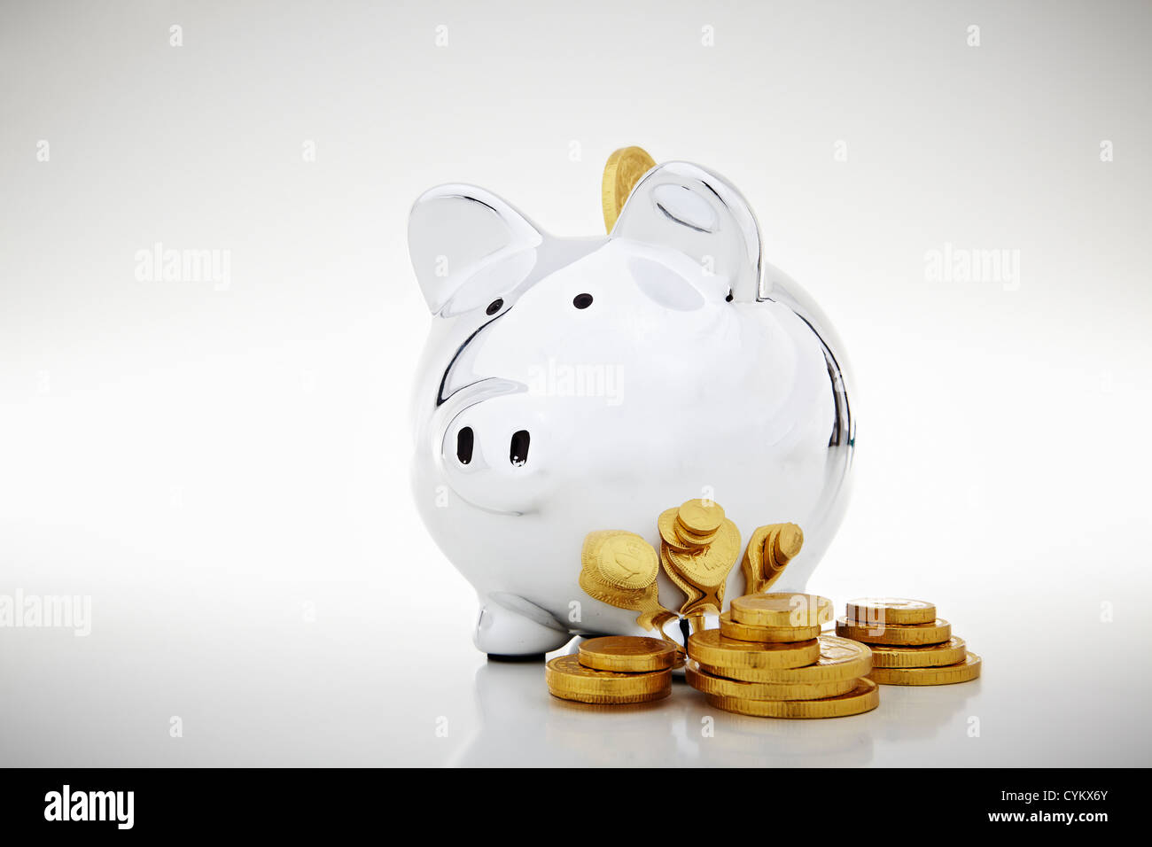 Stack of gold coins by piggy bank Stock Photo - Alamy