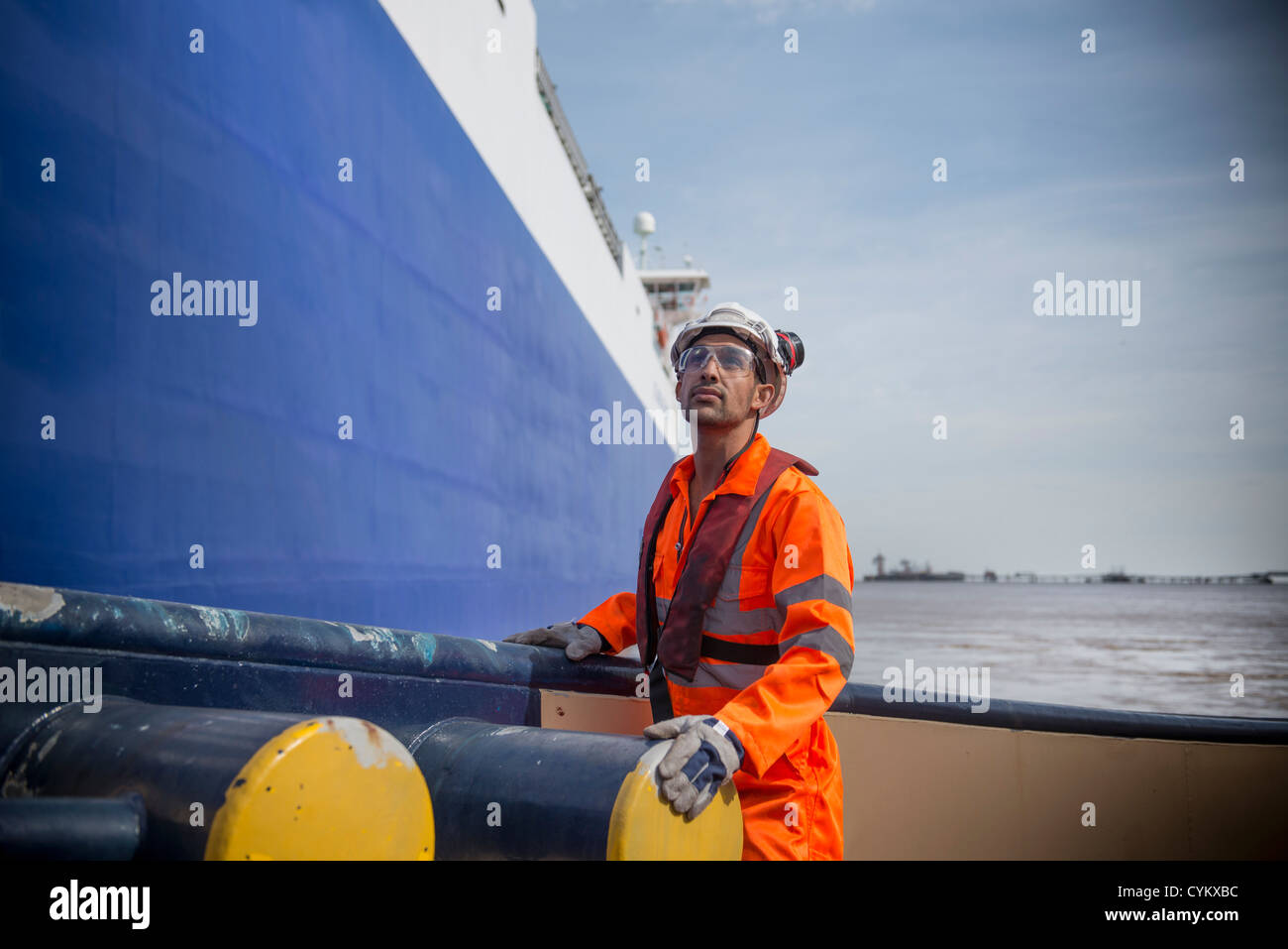 Worker standing on tug boat Stock Photo