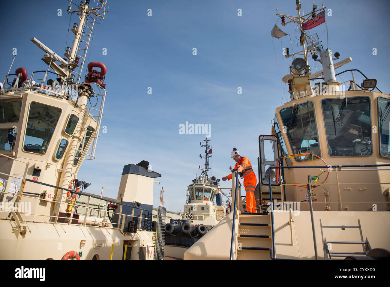 Worker standing on deck of tow boat Stock Photo