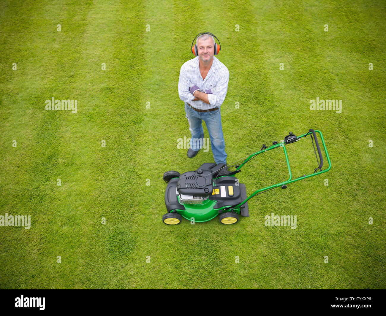 Man standing with lawn mower Stock Photo
