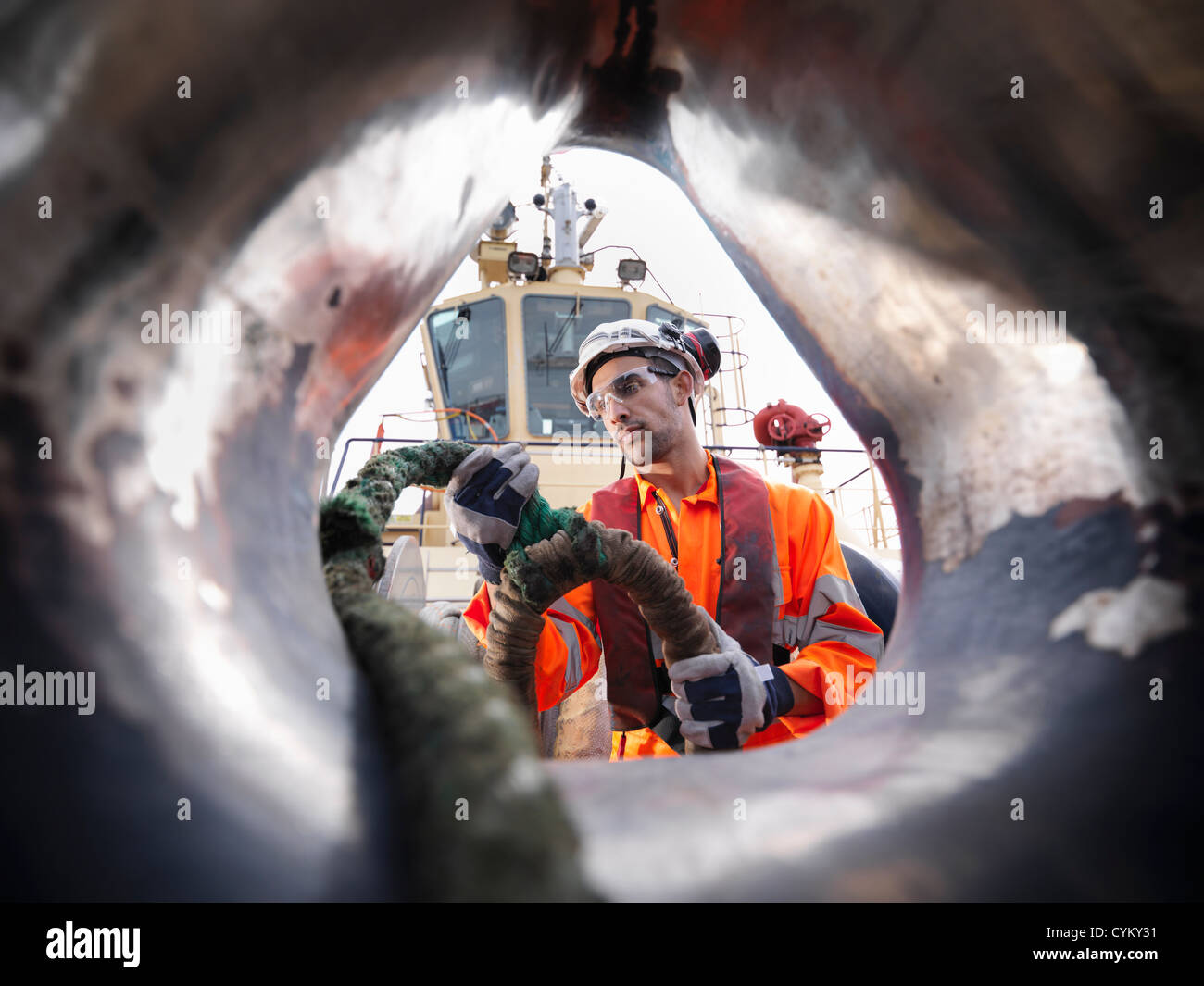 Tugboat worker pulling rope on deck Stock Photo