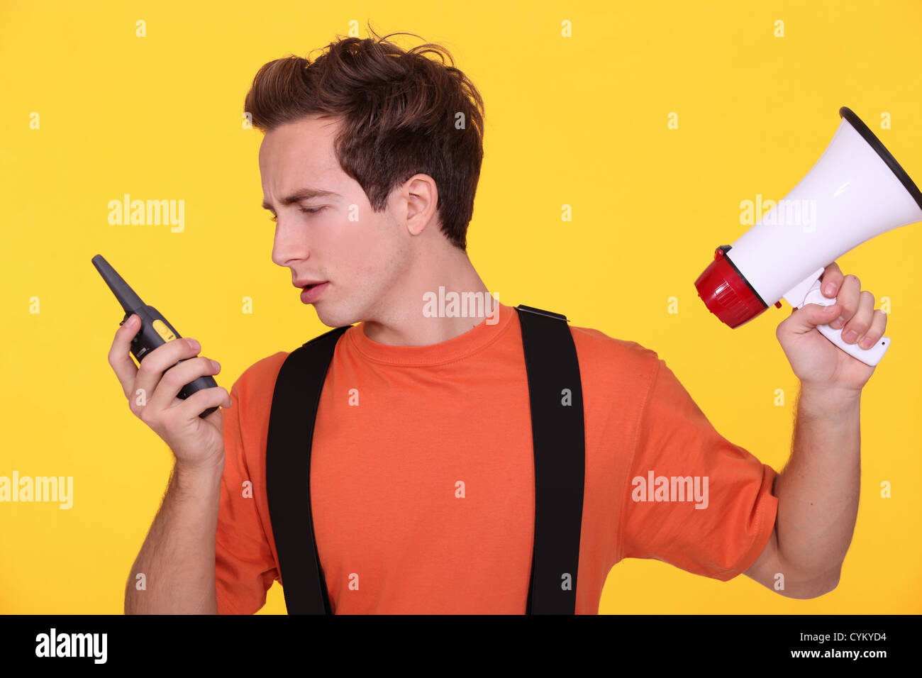 Confused man with a loudspeaker and walky-talky Stock Photo - Alamy