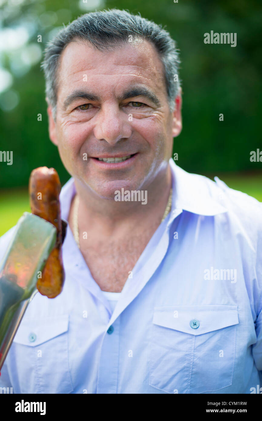 Smiling man grilling hot dog outdoors Stock Photo Alamy