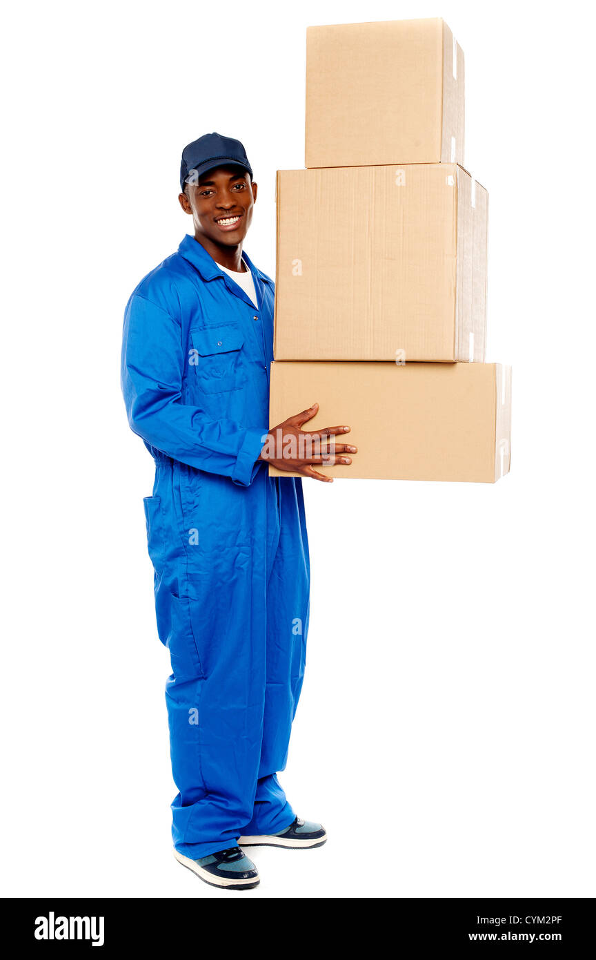 Smiling young delivery boy holding cardboard boxes isolated on white background Stock Photo