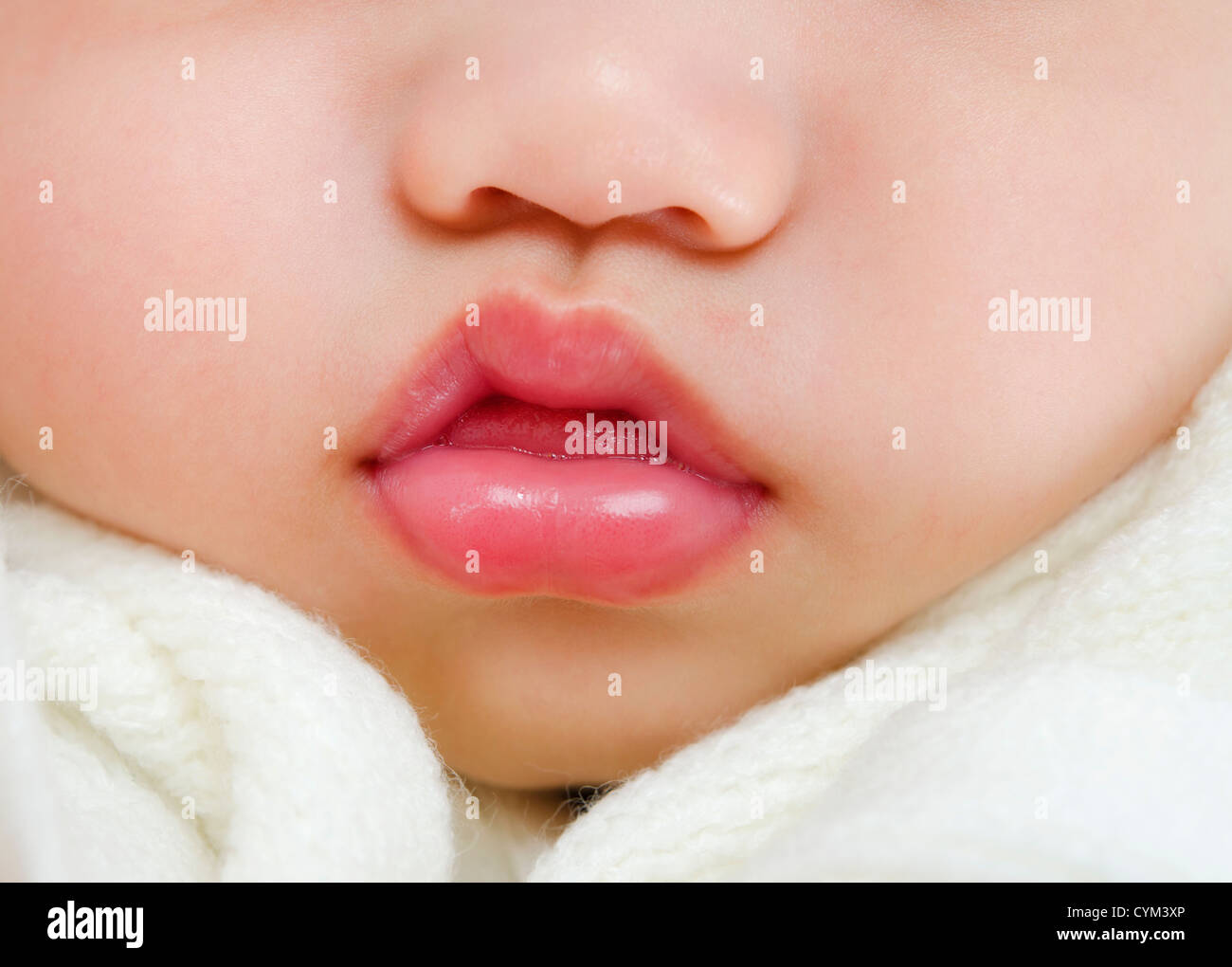 Close up pink lips of a sleeping baby boy with tongue sticking out Stock Photo