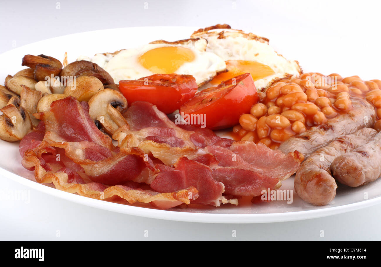 Traditional English breakfast - tomatoes, fried sausages, bacon ...