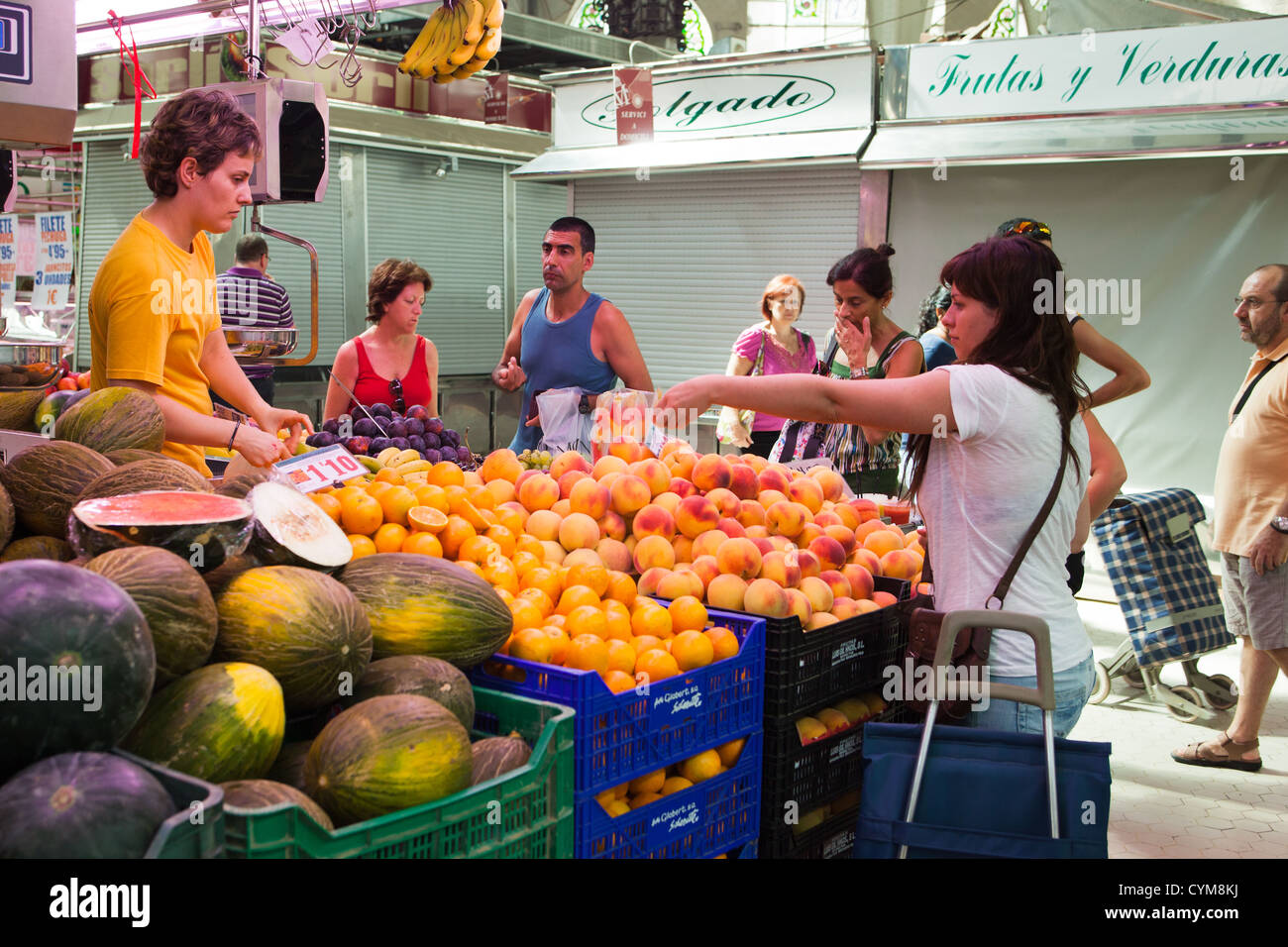 Woman buying fruit and money exchanging hands.Valencia Indoor market. Spain. Mercado central Stock Photo